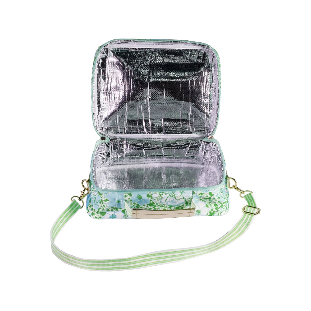 A inside photo of a green, white and blue floral patterned lunch bag with a zipper, strap and handle with silver interior on a white background.
