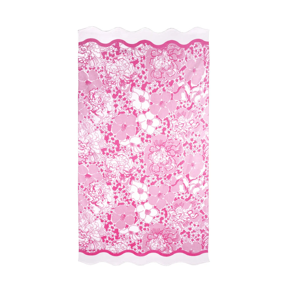 Floral patterned beach towel with pink and white design on a white background.