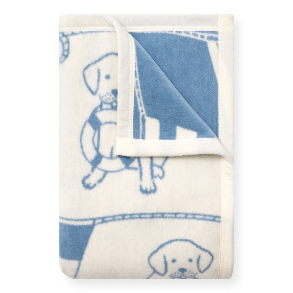 Folded blanket with blue dog illustrations on a white background