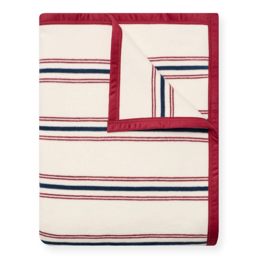 A folded throw blanket with a cream background, featuring thin horizontal navy blue and red stripes, and a solid red border.
