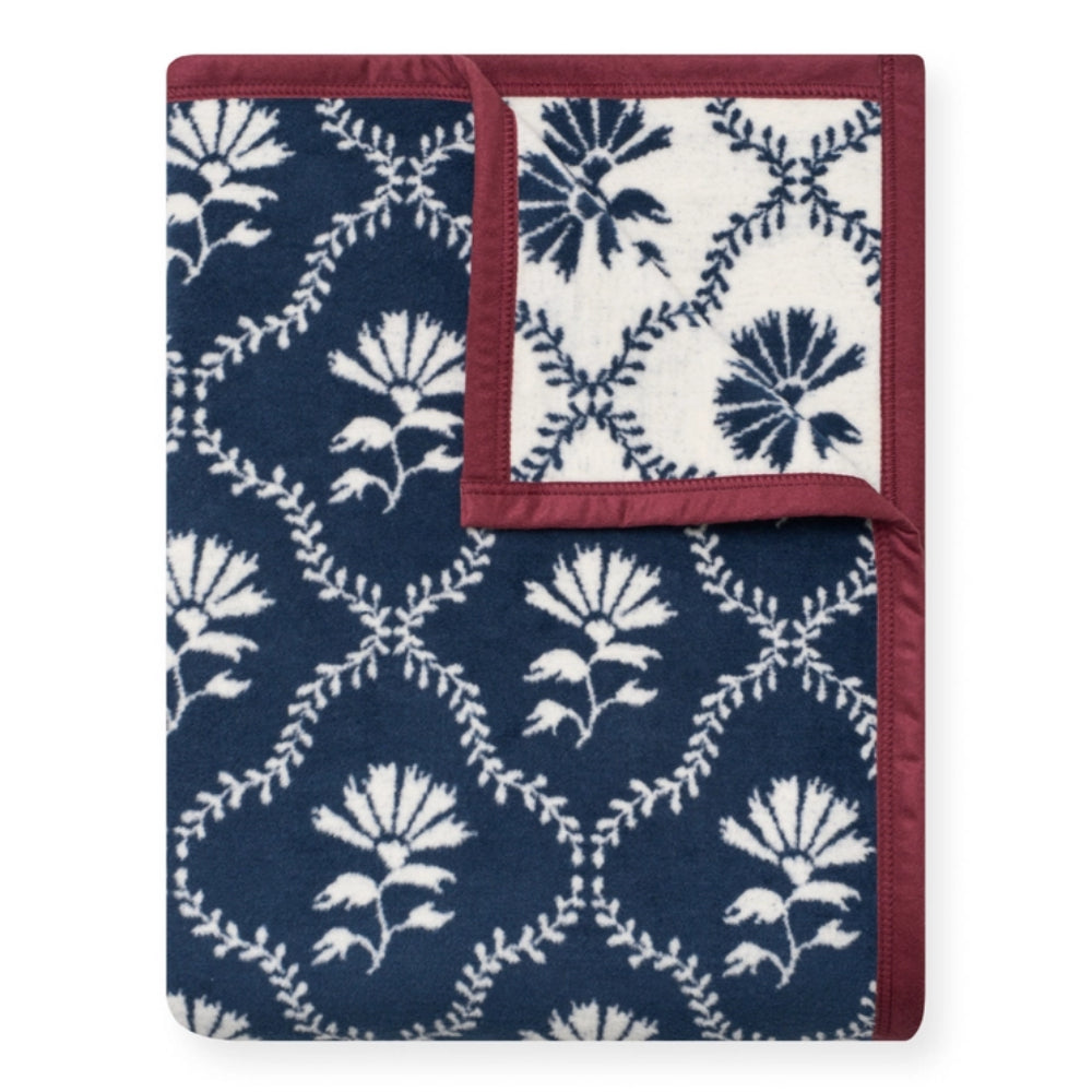 A folded throw blanket featuring a navy blue and white floral damask pattern with a contrasting burgundy border, shown against a plain white background.