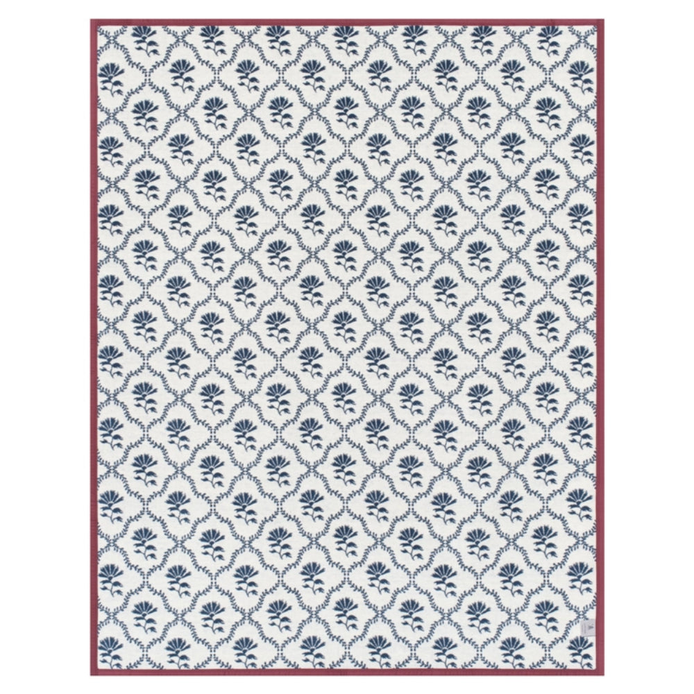 A rectangular blanket with floral designs on a white background. 