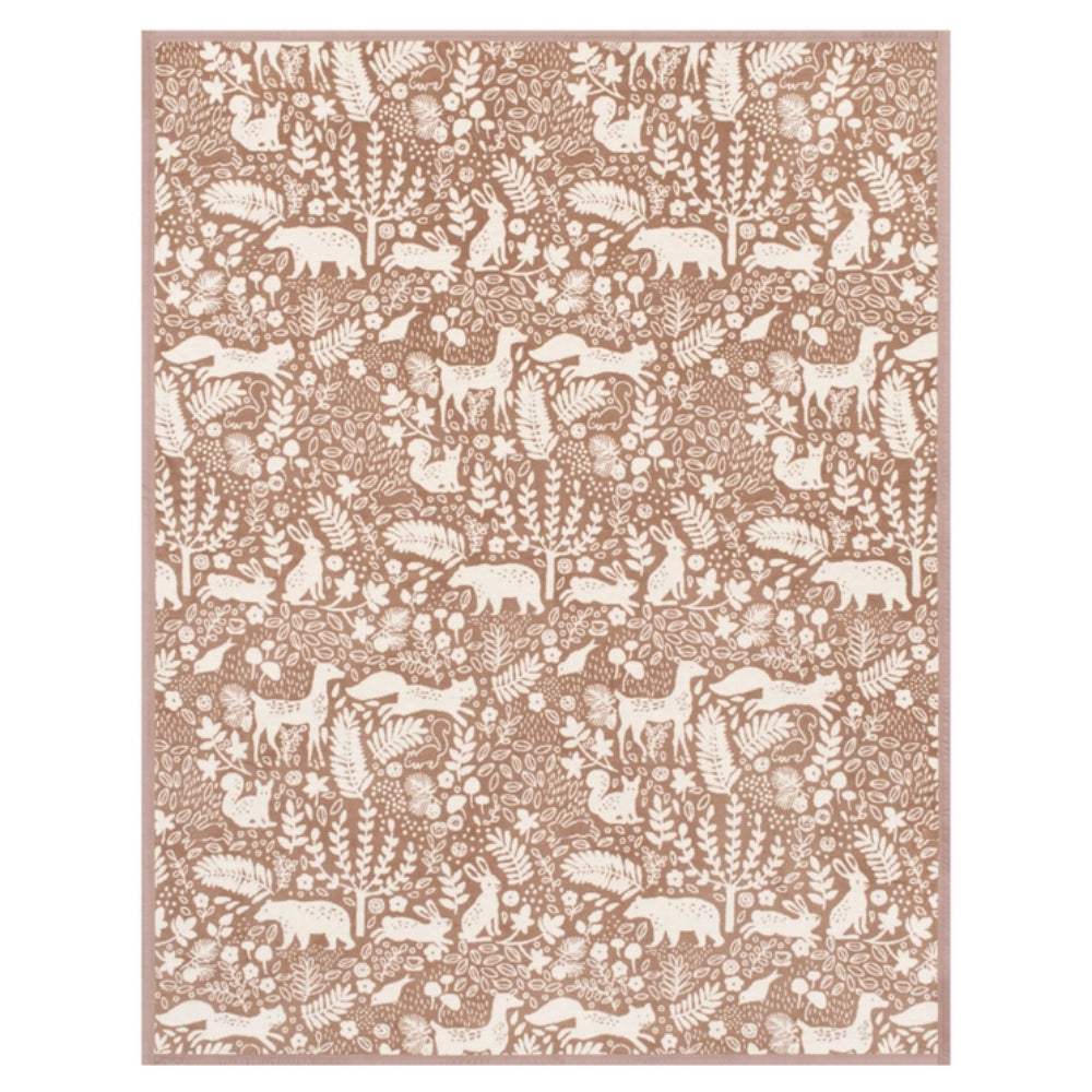 A rectangular blanket featuring a dense woodland pattern of deer, bears, birds, and trees in a warm taupe-brown and cream colorway, shown flat against a white background.