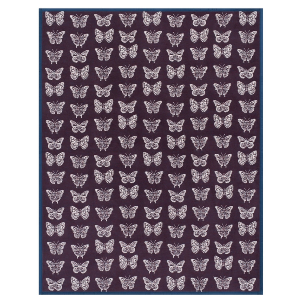 A rectangular blanket with a dark purple background, featuring a repeating pattern of white butterflies and a solid dark blue border.
