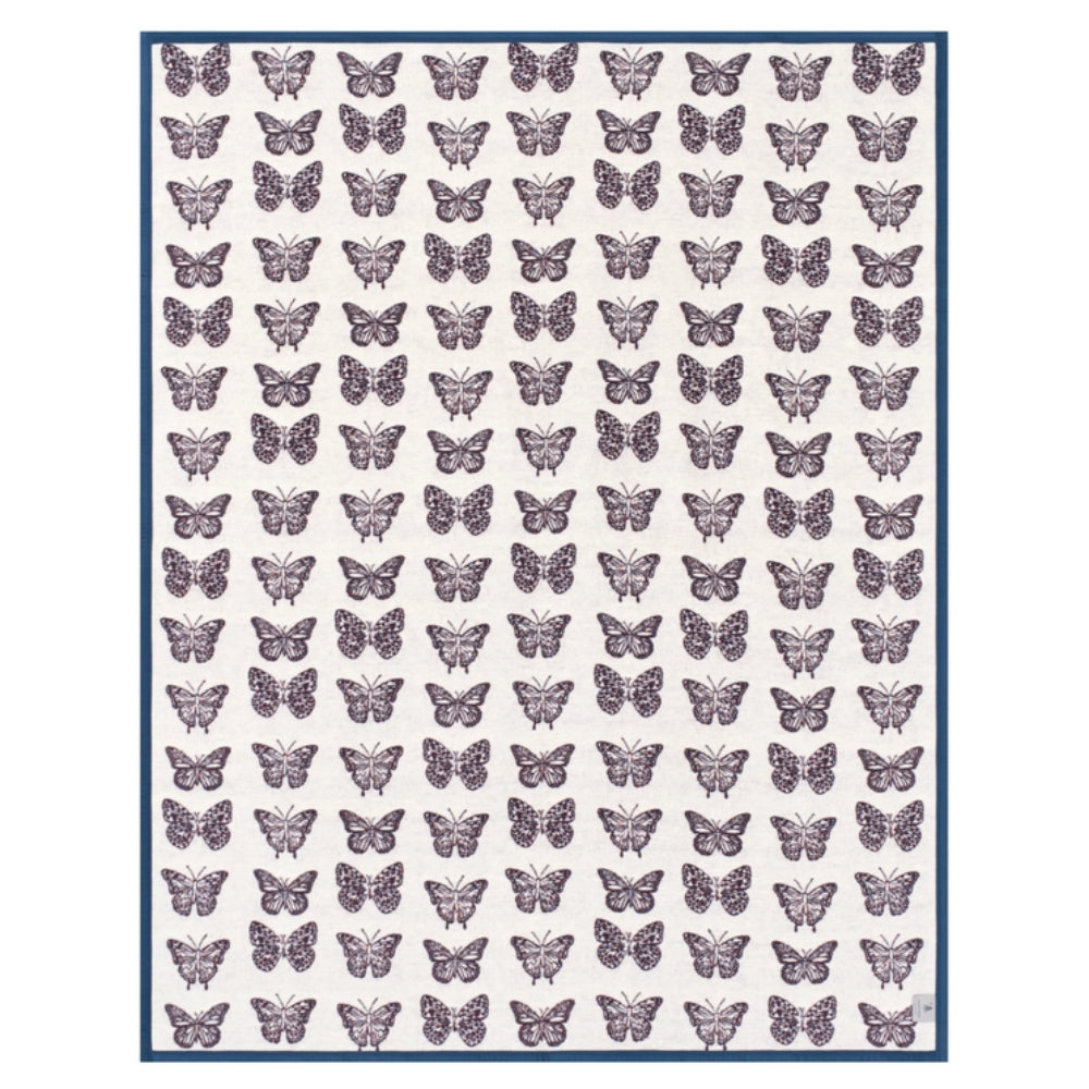 A rectangular blanket with an off-white background, featuring a repeating pattern of small purple butterflies and a solid blue border.