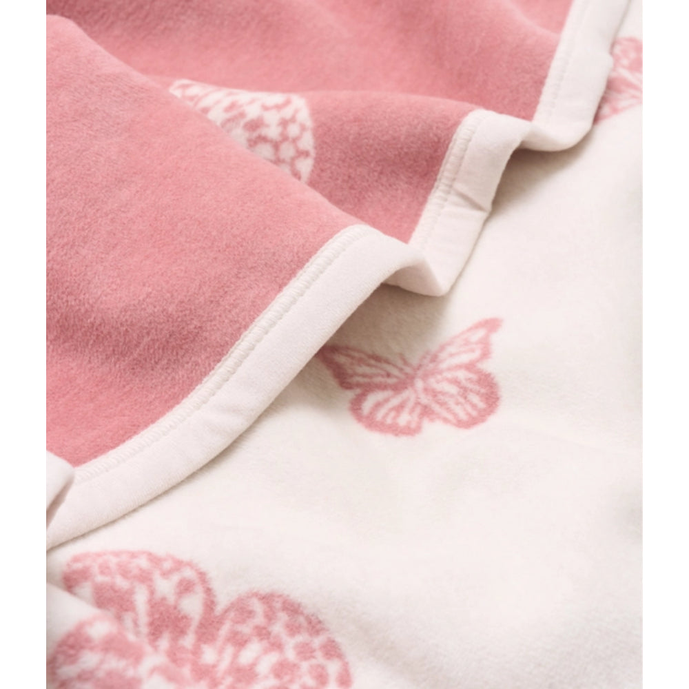 A close-up of a soft fleece blanket with a pink border and a white body featuring a pink butterfly pattern.