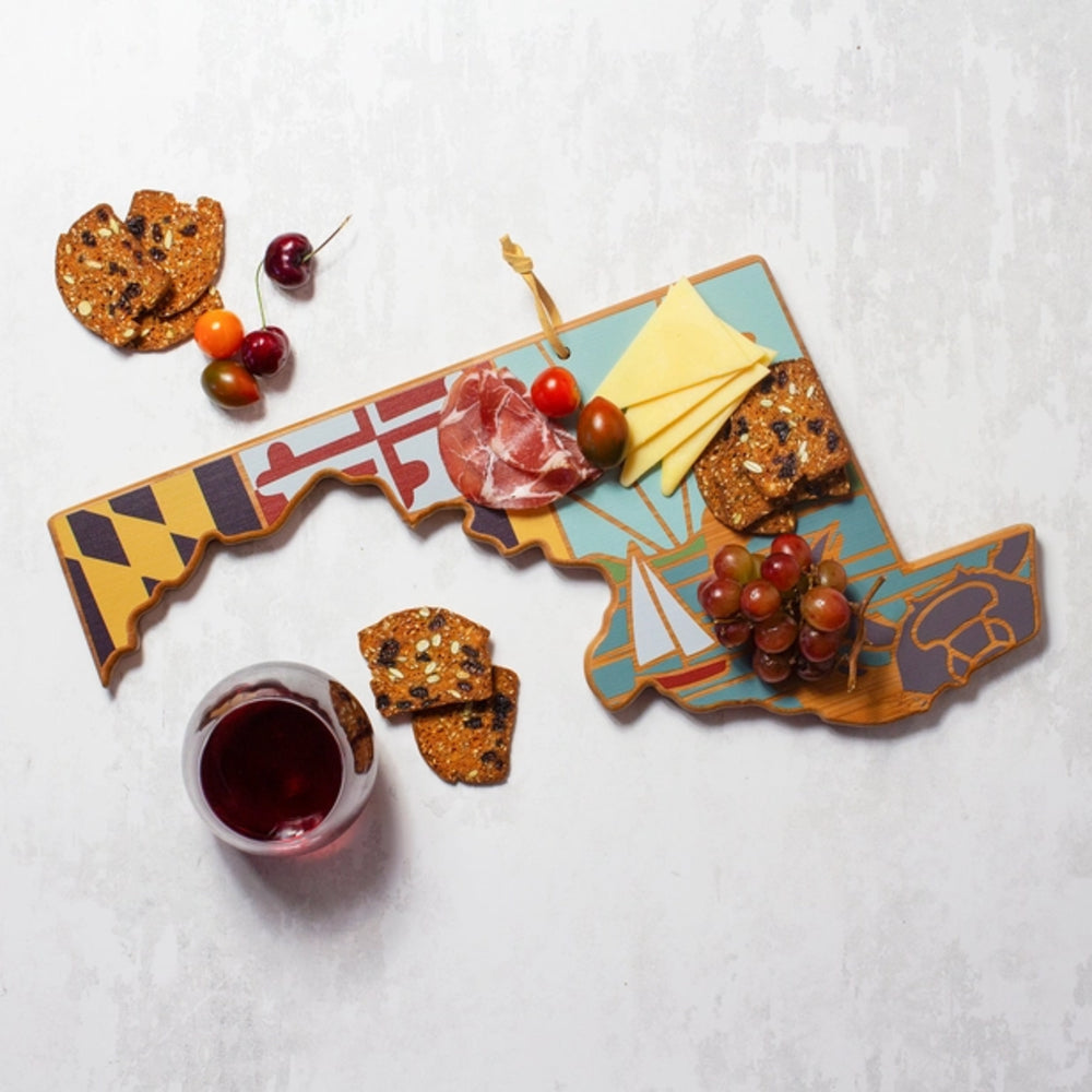 State-shaped charcuterie board with various food items on a gray background.