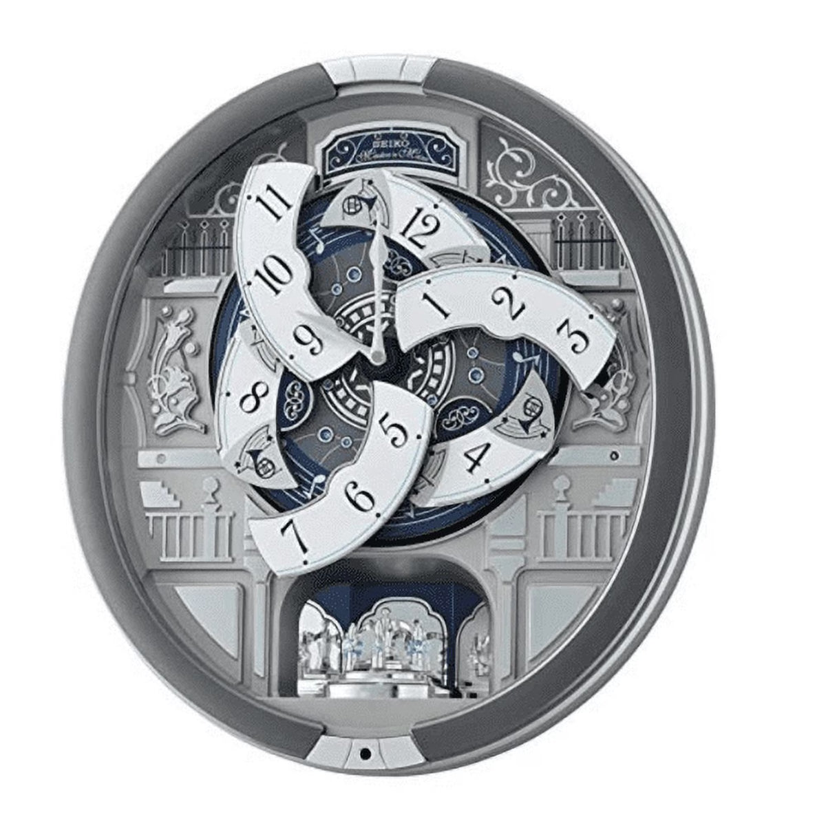 A circular mechanical wall clock by Seiko, featuring floating white clock face segments with black Arabic numerals, set against a detailed silver and blue architectural interior.