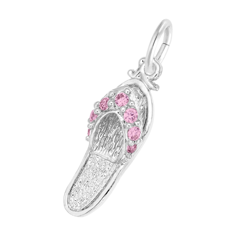 A silver charm shaped like a flip-flop sandal, featuring textured silver detailing and a row of round pink gemstones along the strap, set against a plain white background.