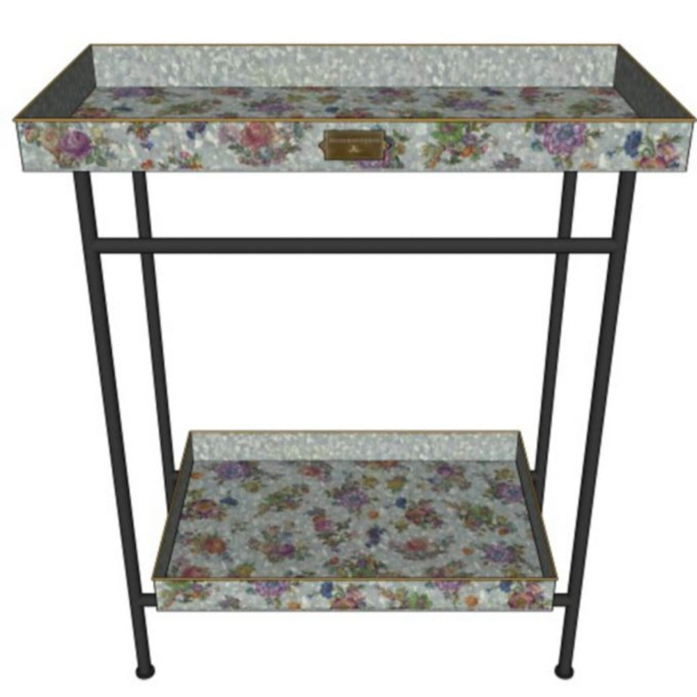 A small  galvanized metal table with floral patterned top and bottom shelf on a white background
