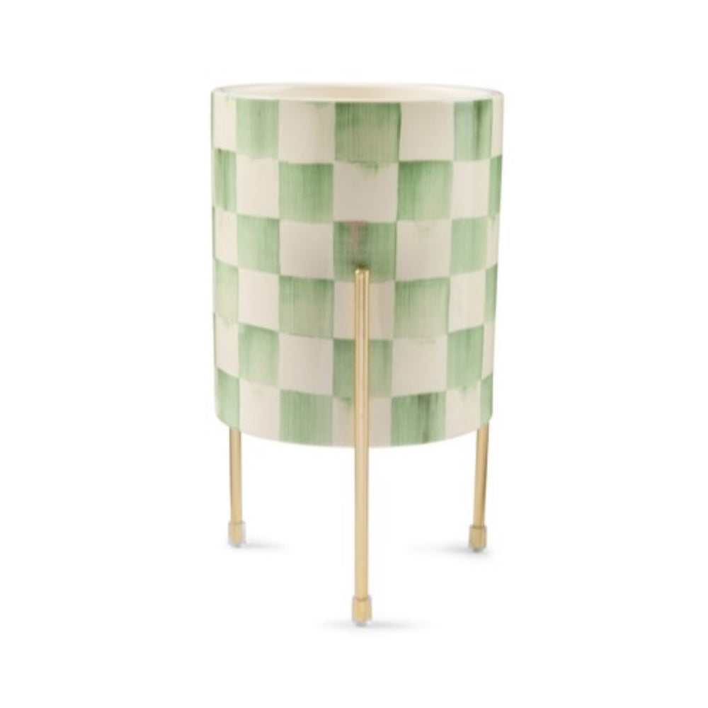 A cylindrical side table with a green and white checkered pattern on the top and three slim gold metal legs, shown against a plain white background.
