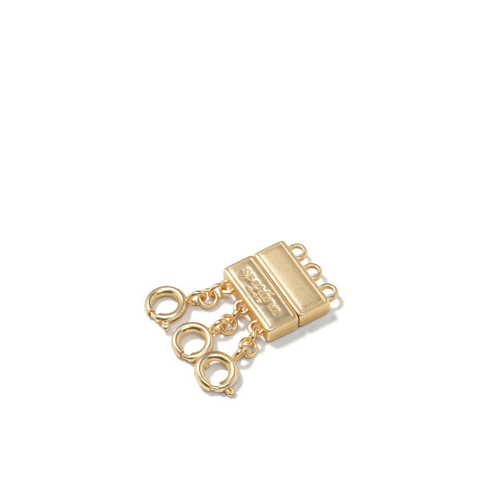 A gold-toned metal necklace clasp with a rectangular body, short chain links, and three hanging oval rings, shown on a plain white background.