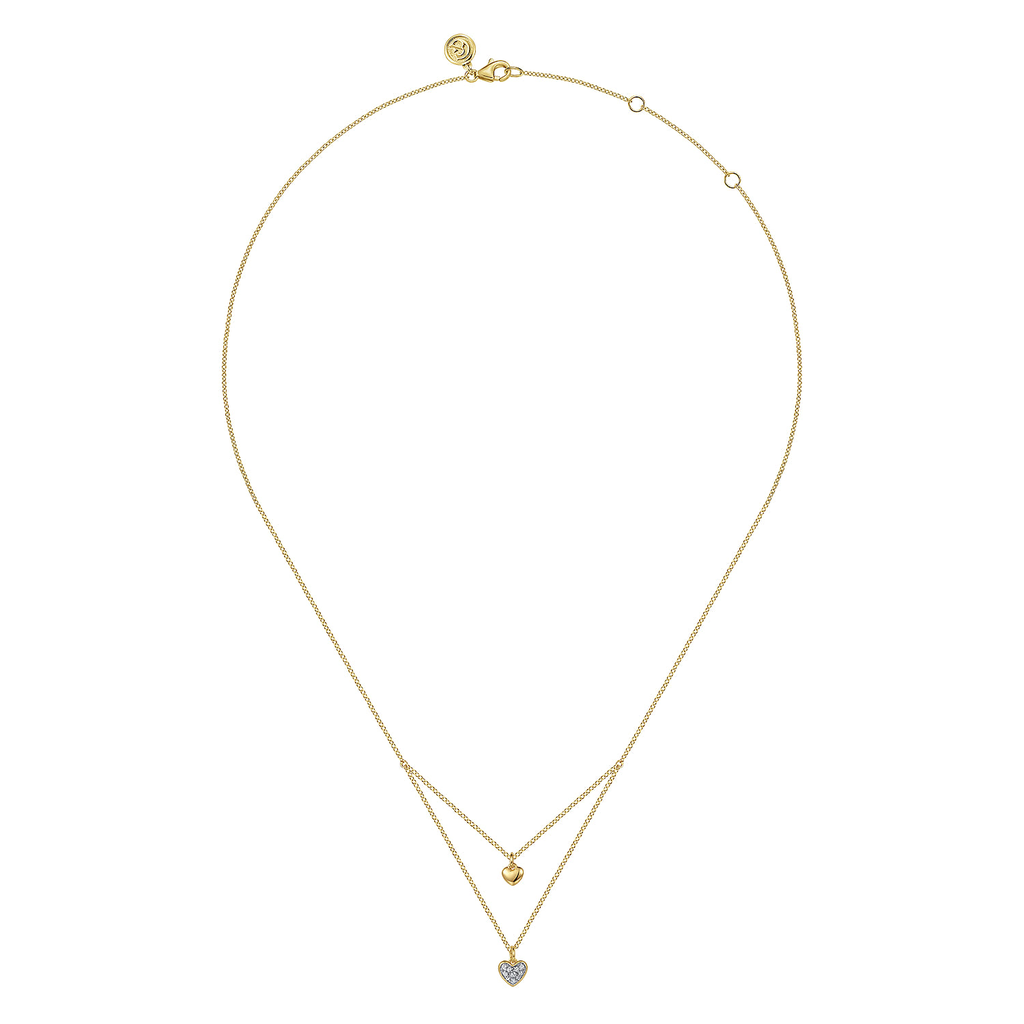Gold necklace with heart-shaped pendant on a white background