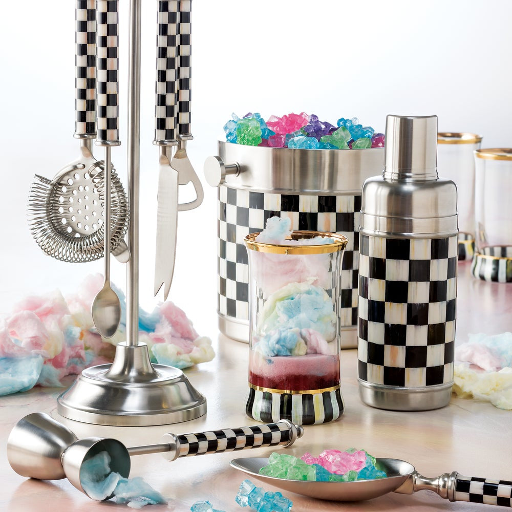 Cocktail-making tools with checkered patterns and colorful ice cubes on a white background