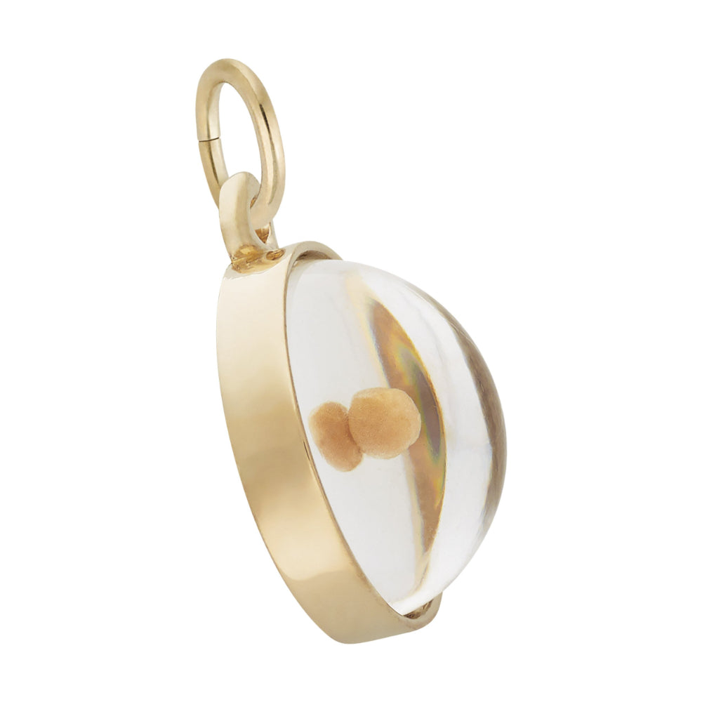 Gold pendant with a white face and brown heart on a white background