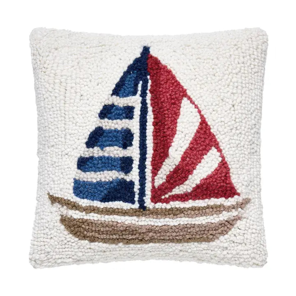 Decorative pillow with a coloful sailboat design on a white background.