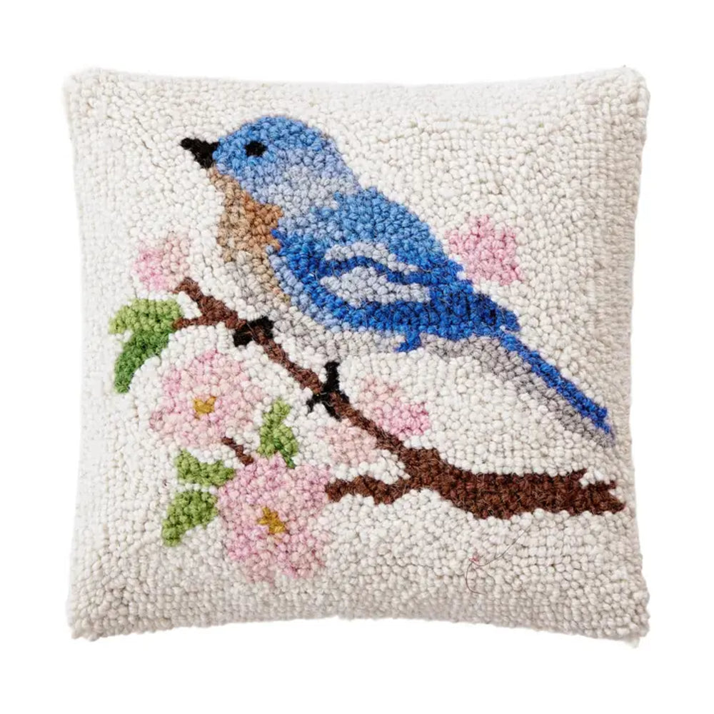 Decorative pillow with a blue bird and pink flowers on a white background