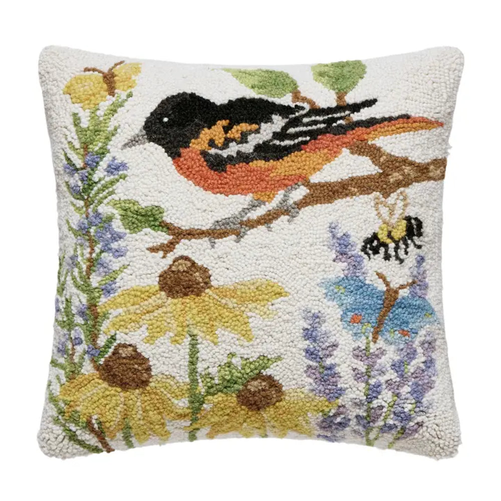 Decorative pillow with a bird, bee, and flowers on a white background.