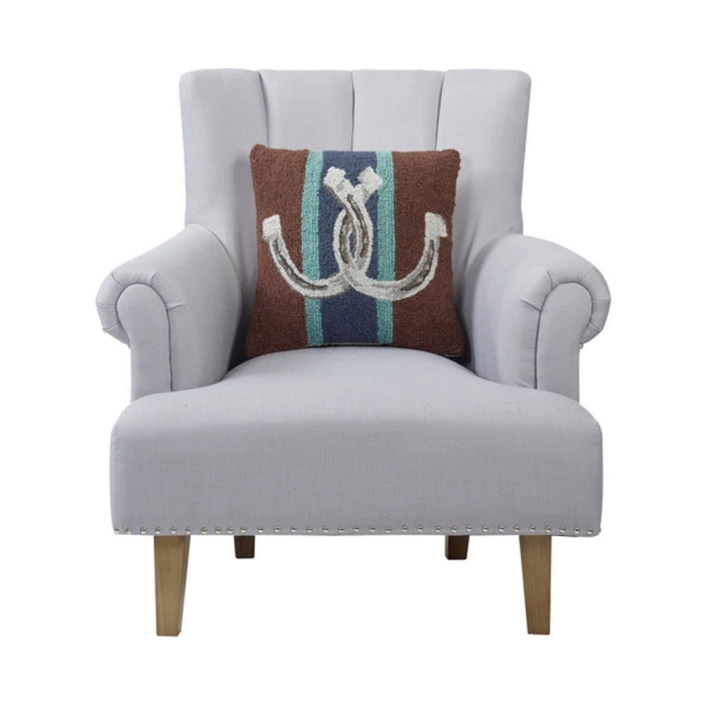 A light gray upholstered accent chair with rolled arms, nailhead trim, and tapered wooden legs, shown against a white background with a decorative throw pillow.