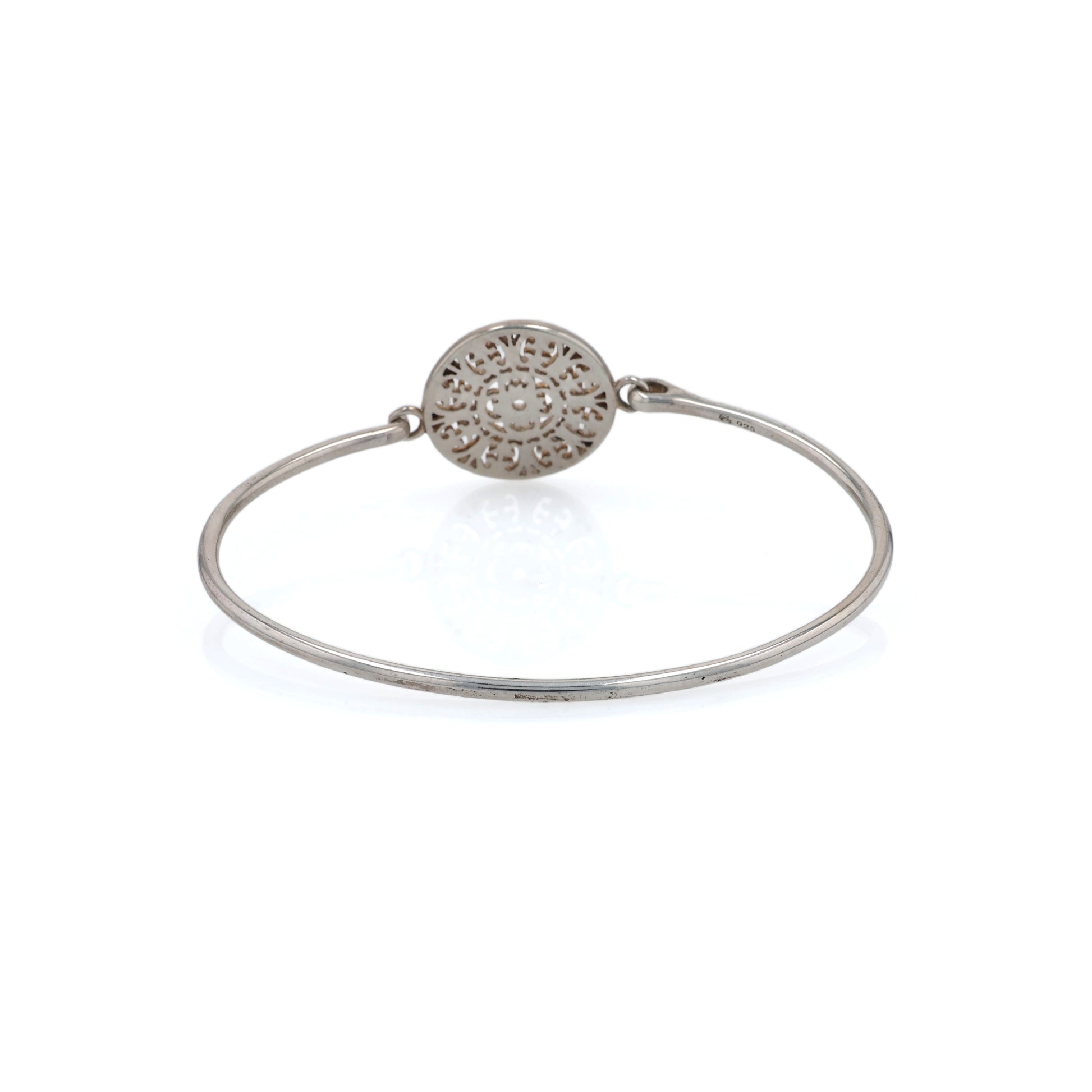 Back of Silver bracelet with a decorative circular medallion on a white background