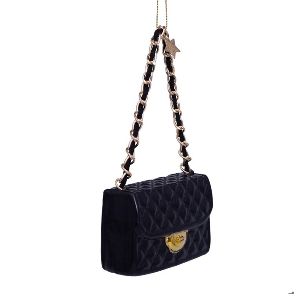Black quilted handbag ornament with gold chain strap on a white background