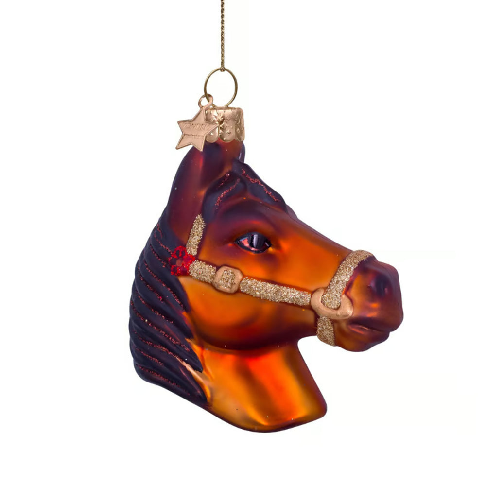 Glass horse head ornament with a bridle on a white background