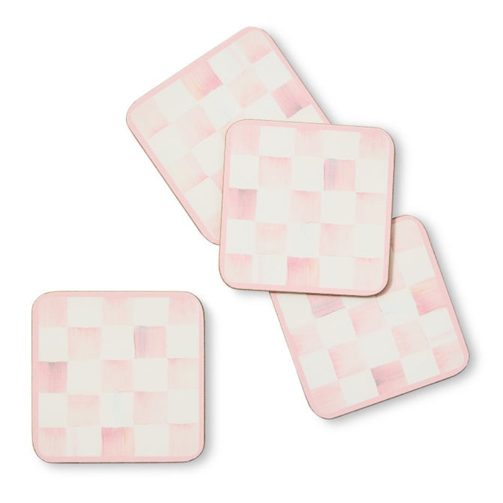 Set of four pink and white checkered coasters on a white background