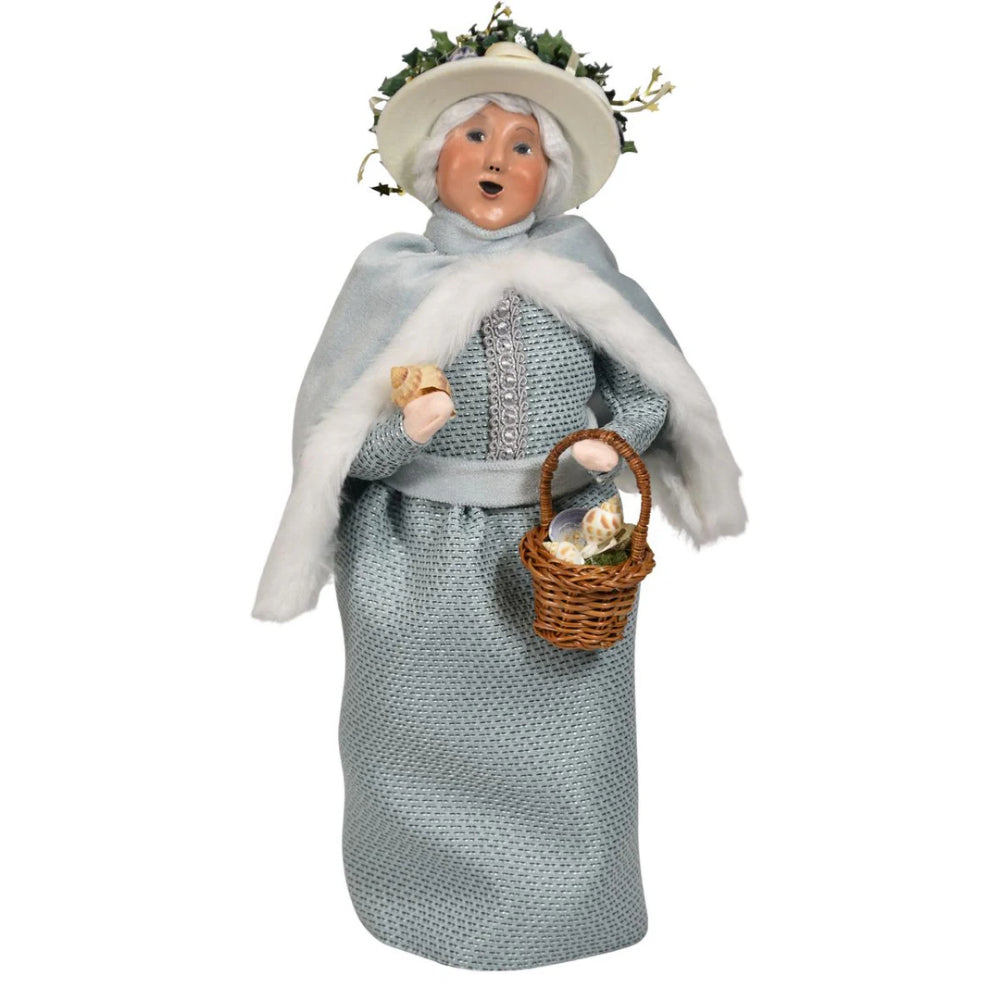 Decorative figurine of nautical mrs.claus in traditional attire with a basket on a white background
