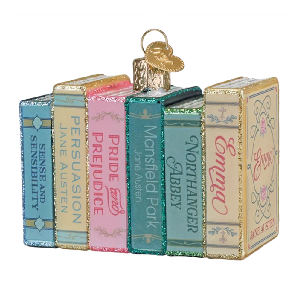 A decorative ornament shaped like a row of vintage hardcover books standing upright, with a gold hanging loop at the top. The book spines are shown in pastel blue, cream, gold, pink, teal, and mint, with titles including Sense and Sensibility, Pride and Prejudice, Mansfield Park, Northanger House, and Emma.