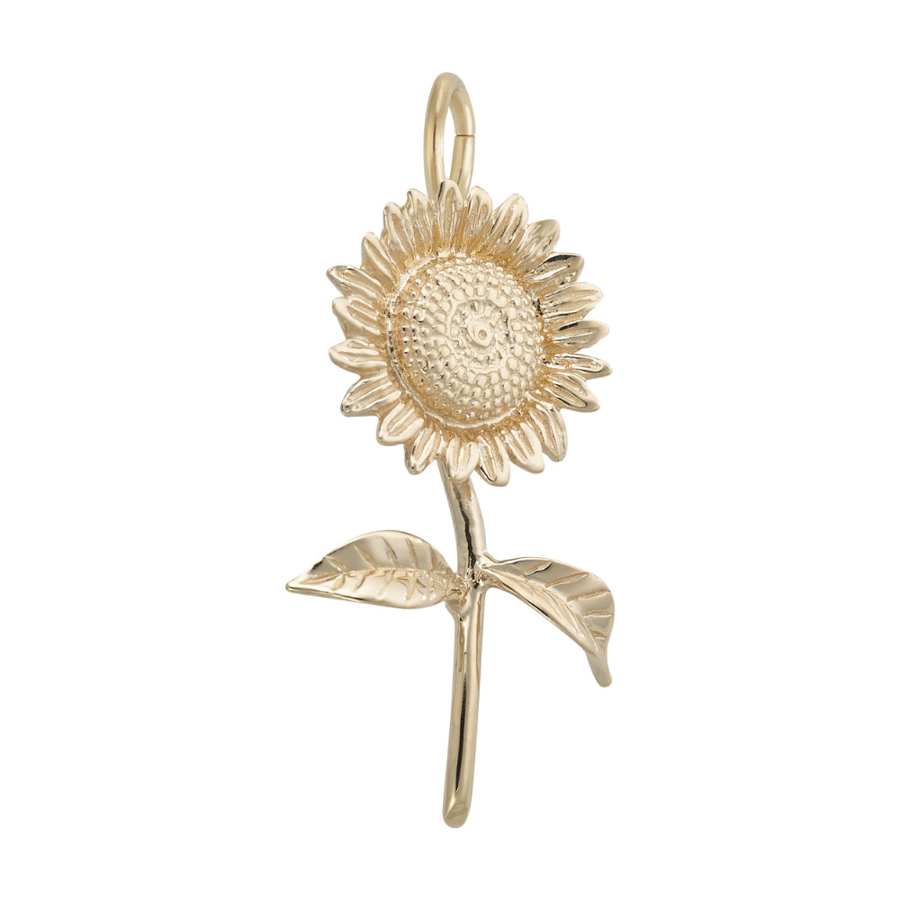 A 3/4 view of A gold sunflower charm pendant with detailed petals, a textured center, and two leaves on a stem, shown against a plain white background.