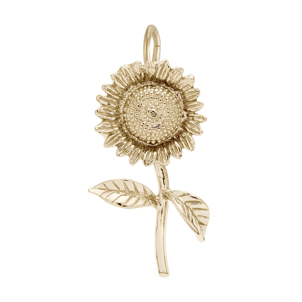 A gold sunflower charm pendant with detailed petals, a textured center, and two leaves on a stem, shown against a plain white background.