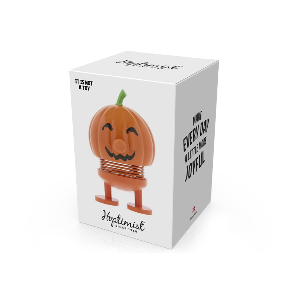 A white rectangular product box for Hoplimist, featuring a cartoon jack-o'-lantern figure with an orange pumpkin head, smiling face, green stem, and copper-colored spring body with legs. The box has black text including 'IT IS NOT A TOY' and 'MAKE EVERY DAY A LITTLE MORE JOYFUL'.