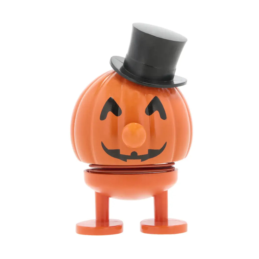 An orange jack-o'-lantern toy figure with a black top hat, black facial features, and orange legs, shown against a plain white background.
