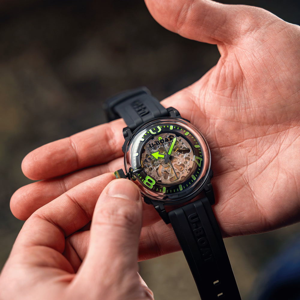 black watch in person's hand on dark background