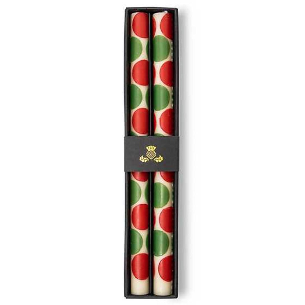Two candles with red and green polka dot pattern in a black box on a white background