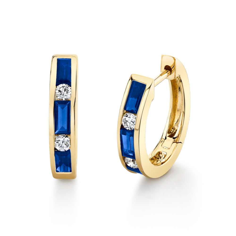 Gold hoop earrings with blue gemstones and clear stones on a white background