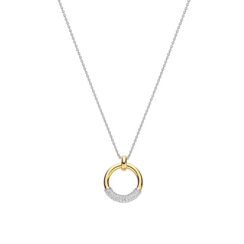 A delicate silver chain necklace featuring a circular pendant with a polished yellow gold top half and a pavé-set silver bottom half, shown on a plain white background.