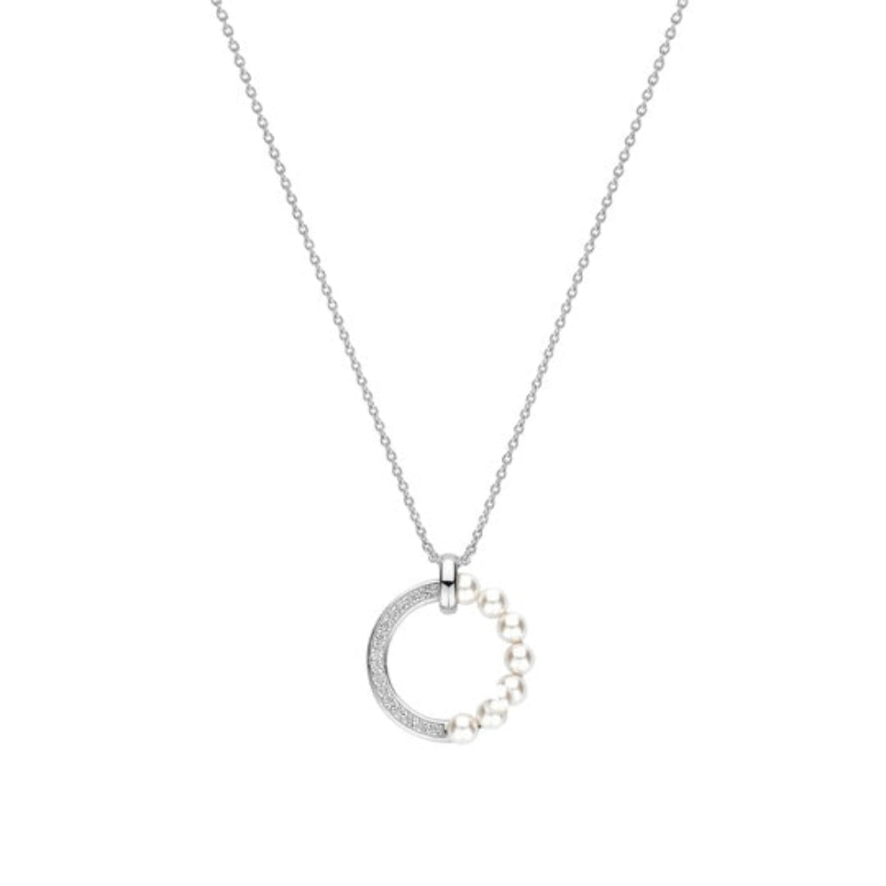 A silver chain necklace witha circle pendant, where one side of the circle is encrusted with small clear stones and the other side is lined with white pearls, shown against a plain white background.