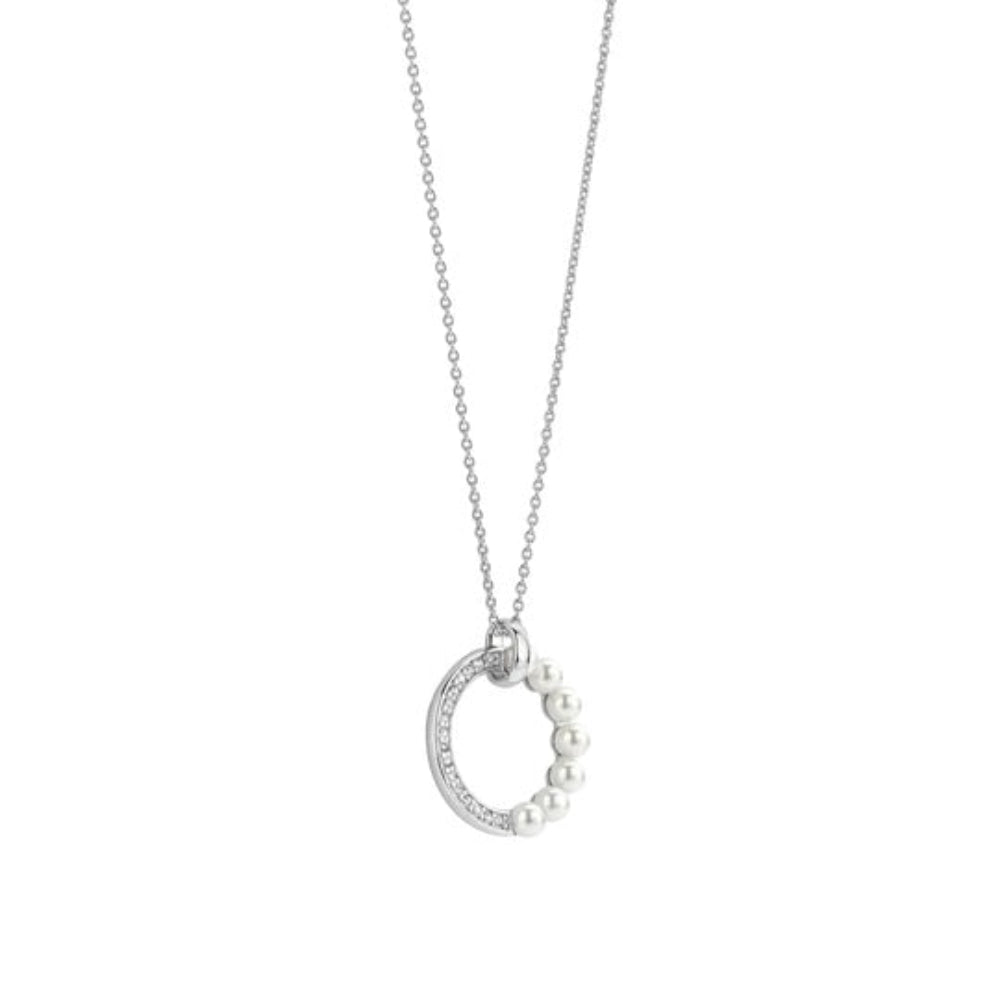 A silver necklace featuring a circular pendant adorned with small white pearls and a line of clear rhinestones 
