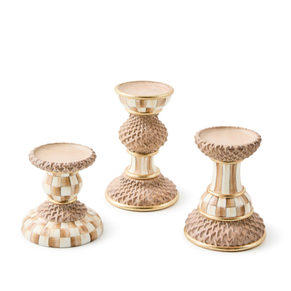 Set of three decorative candle holders with a checkered pattern on a white background