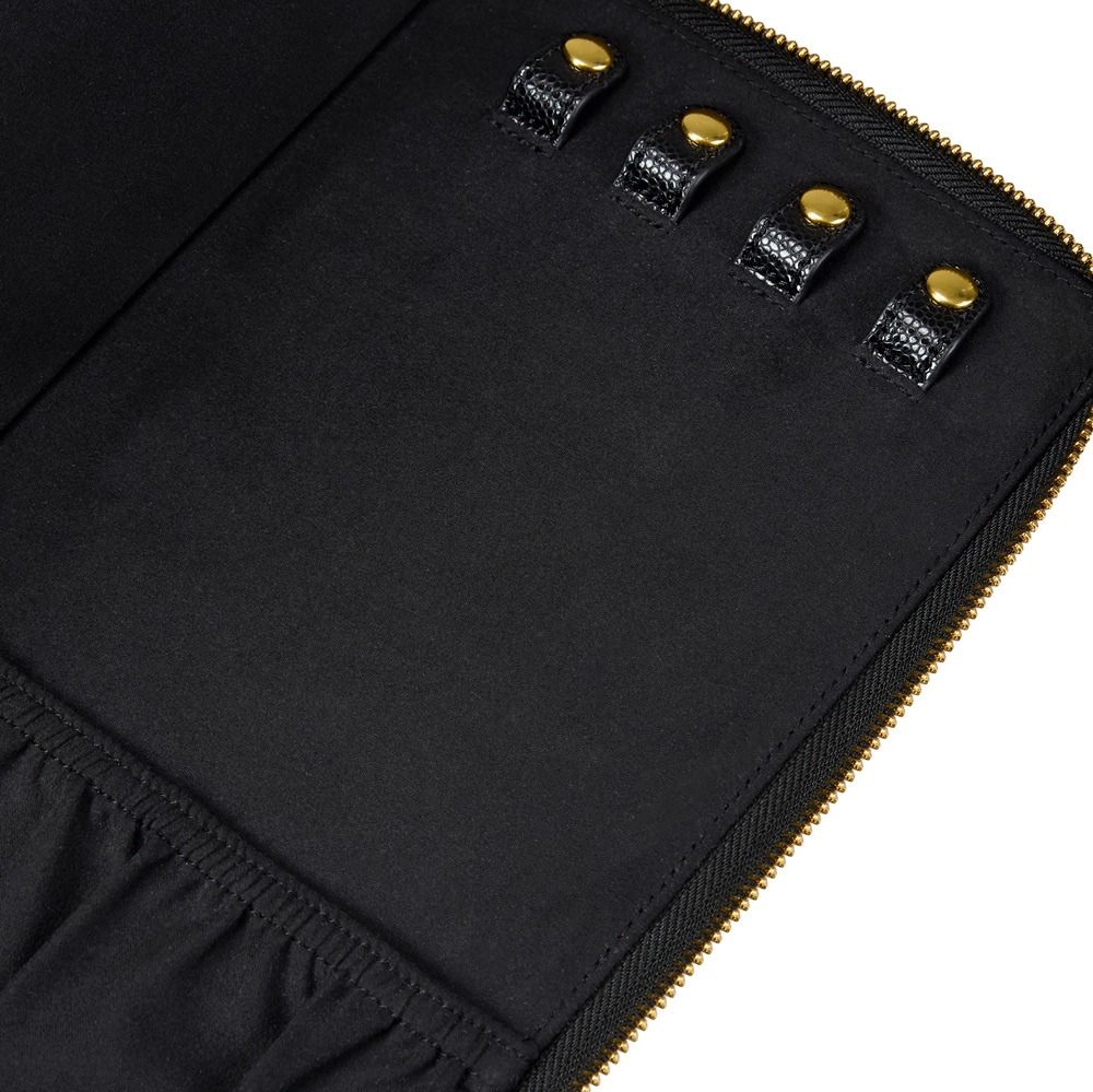 Close-up of a black fabric zippered pouch or organizer with four gold-tone snap buttons and gold zipper trim on a white background.