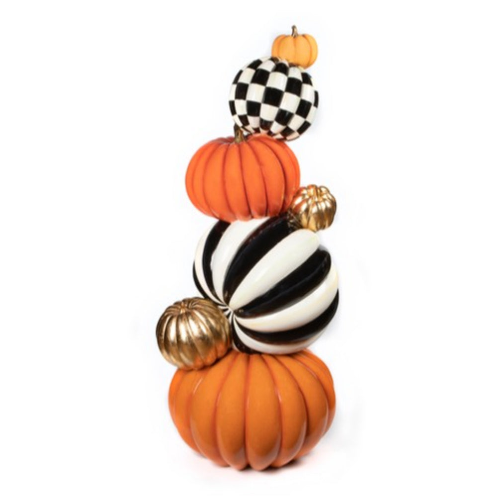 Decorative stack of pumpkins with black and white checkered, striped, and gold designs on a white background.