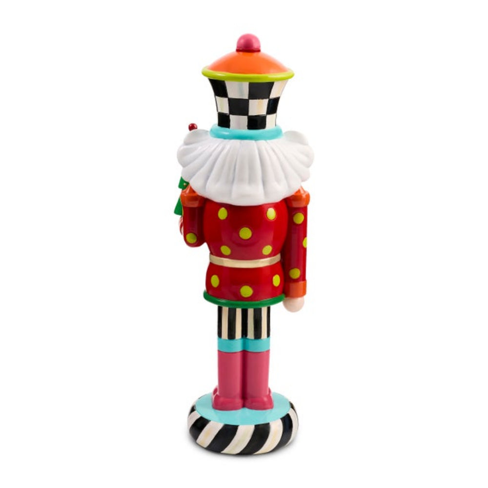 A colorful clown nutcracker figurine shown from the back, featuring a red polka-dot coat, white ruff collar, black-and-white checkered hat, and striped base on a plain white background.