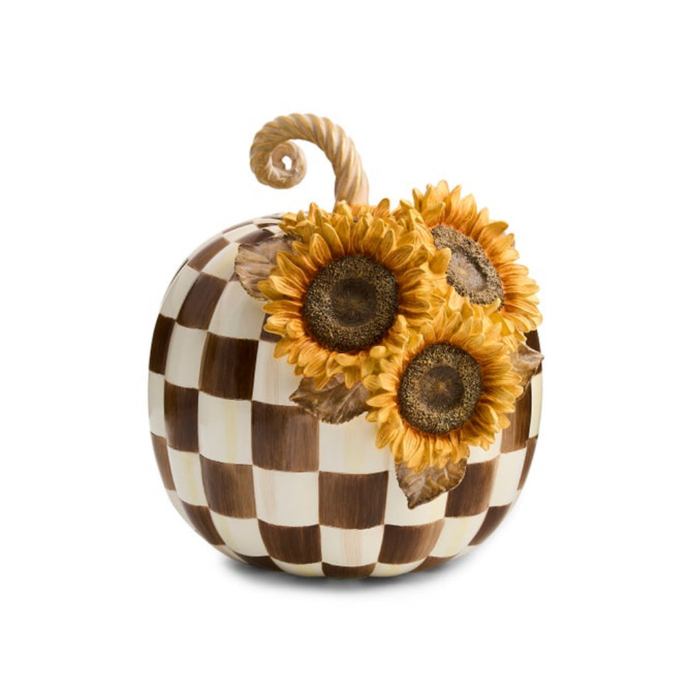 A decorative pumpkin with a brown and cream checkered pattern, adorned with three large yellow sunflowers and a twisted stem, shown on a plain white background.