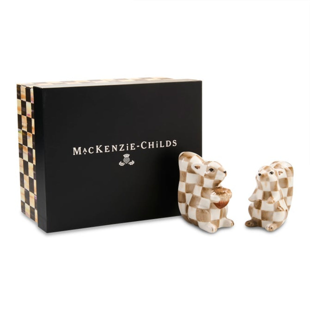 MacKenzie-Childs ceramic squirrel salt and pepper shakers with a checkered pattern, displayed next to their black presentation box on a white background.