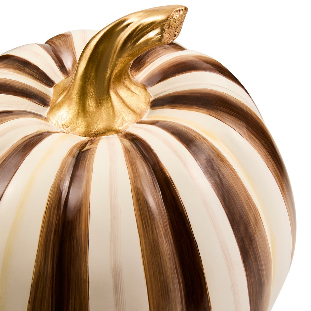 A decorative pumpkin with alternating vertical brown and cream stripes and a metallic gold stem, shown close-up on a white background.