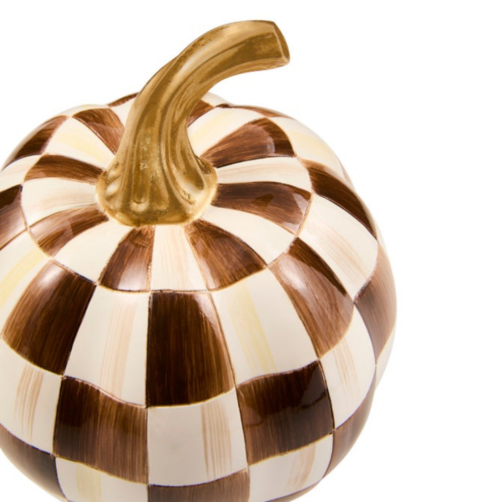 A decorative pumpkin figurine featuring a brown and cream checkerboard pattern with a metallic gold stem, set against a plain white background.