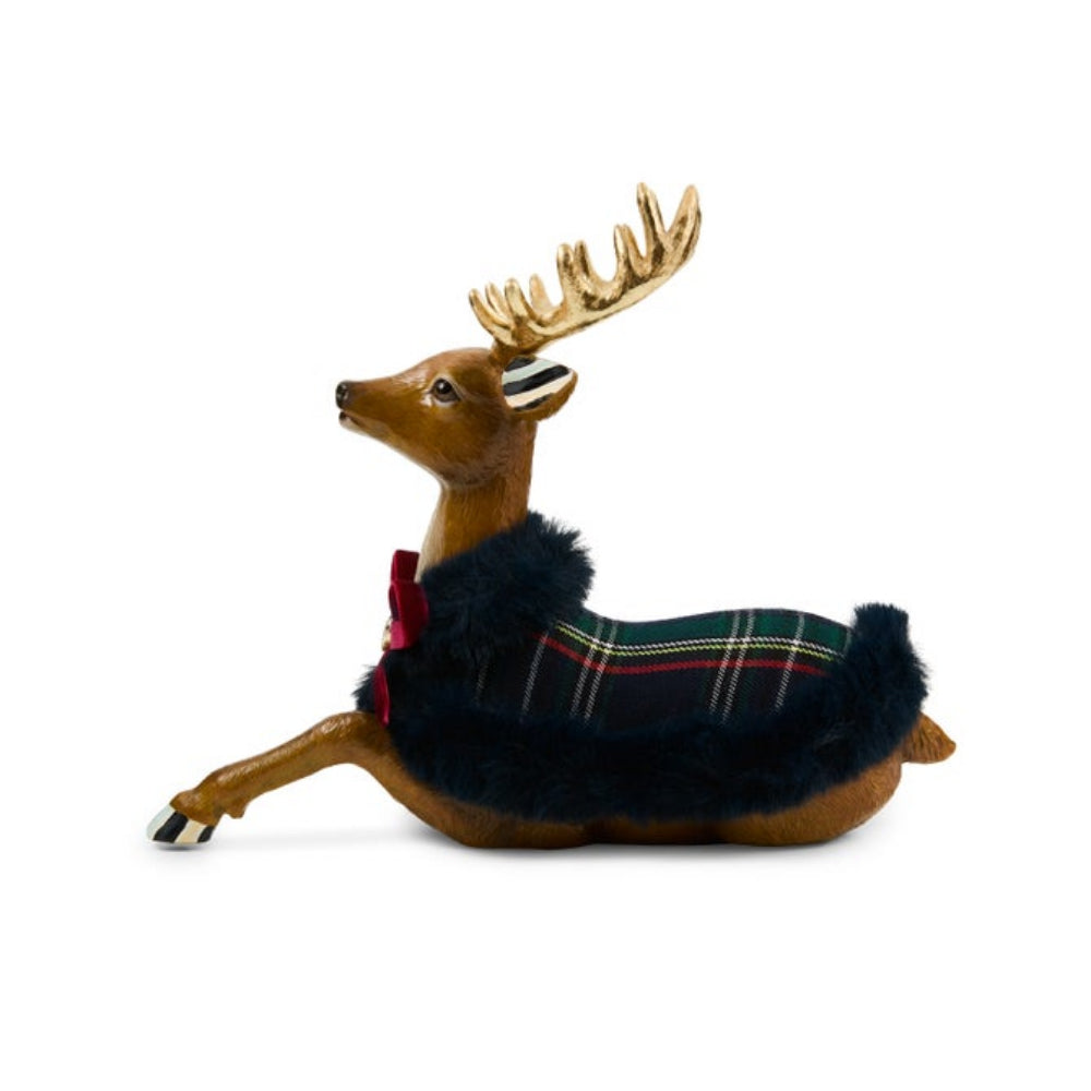 A decorative reindeer figurine with gold antlers, brown body, and a dark navy faux-fur body wearing a green tartan plaid saddle blanket and a red bow, shown on a plain white background.