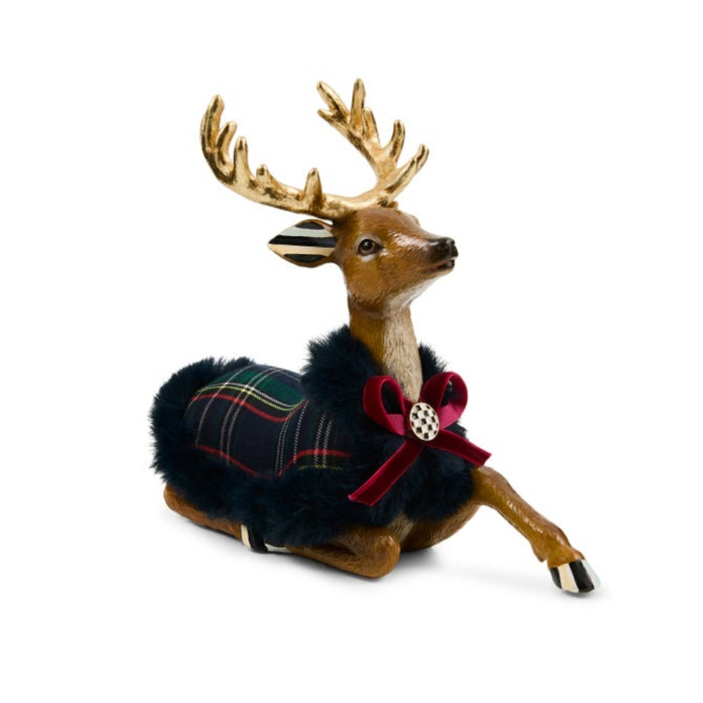 Decorative reindeer figurine wearing a plaid sweater and red bow on a white background