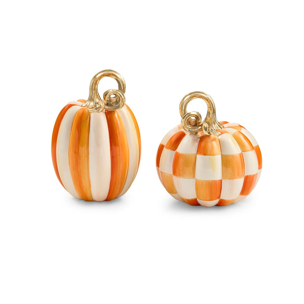 Two small decorative pumpkin charms with gold-tone loops, one featuring vertical orange and cream stripes and the other a checkerboard pattern of orange and cream, on a white background.